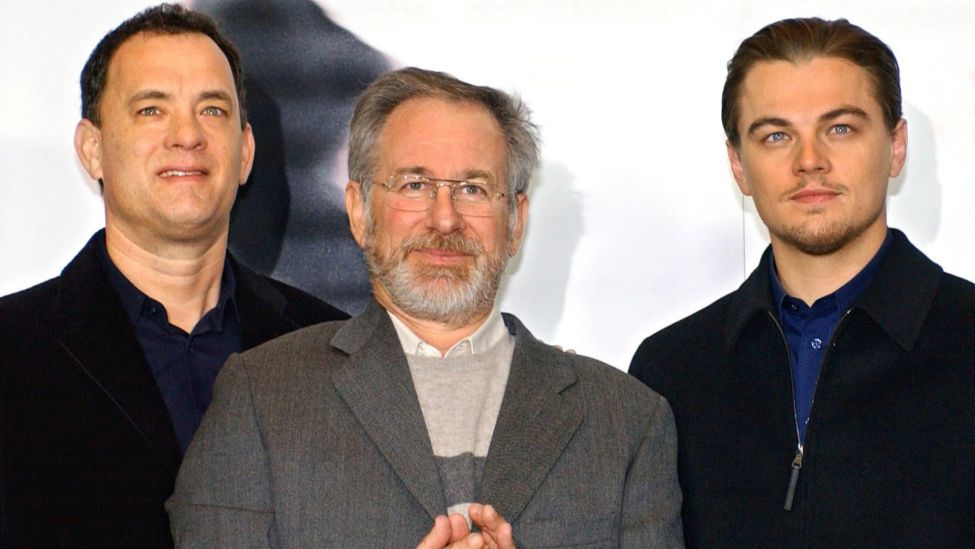 Die US-Schauspieler Leonardo DiCaprio (l.) und Tom Hanks (r.) sowie der Regisseur Steven Spielberg stehen am 26.1.2003 in Berlin vor einem Kinoplakat zu ihrem neuen Streifen "Catch Me If You Can". (Quelle: dpa/Stephanie Pilick)