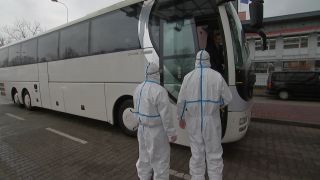 Zwei polnische Beamte kontrollieren einen Reisebus
