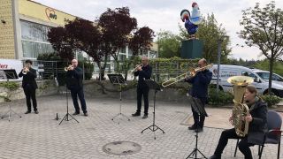 Fünf Blechbläser des Brandenburgischen Staatsorchesters spielen vor einem Seniorenheim in Frankfurt (Oder)