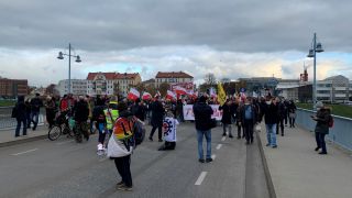 <eine Gruppe Coronaleugner protestiert mit polnischen Flaggen und Regenbogenfahnen auf der Stadtbrücke Frankfu