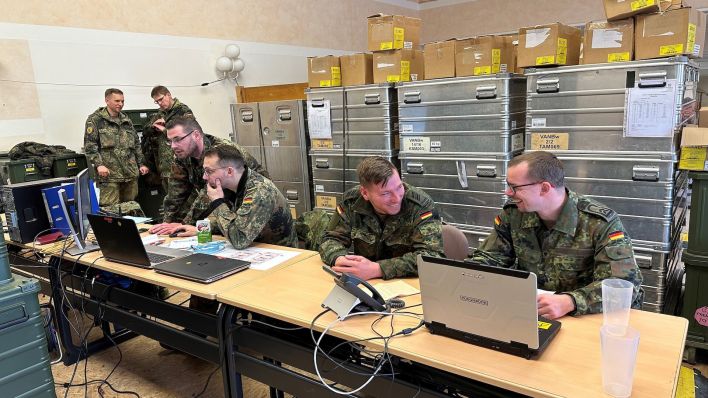 Soldaten sitzen nebeneinander an Computern