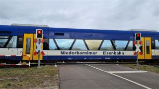 Niederbarnimer Eisenbahn an Bahnübergang/ Schranke