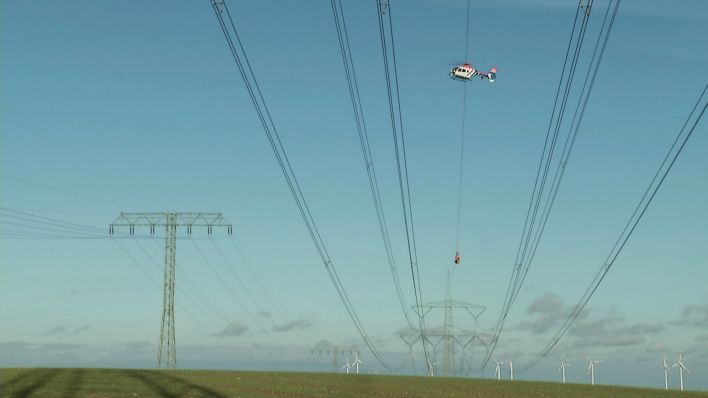 Vogelschutz an Stromleitungen mit Hubschrauber angebracht