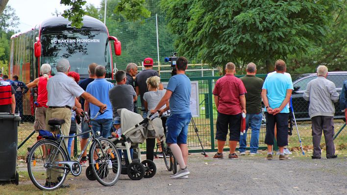 Fußballfans beobachten Traing der Bayern in Cottbus von draußen