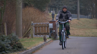 Ein Mann fährt auf dem Fahrrad in eine Hofeinfahrt.