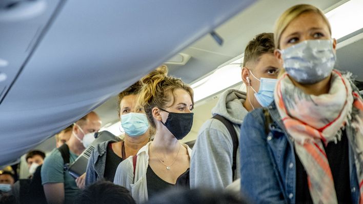 Fluggäste mit Masken (Bild: dpa)