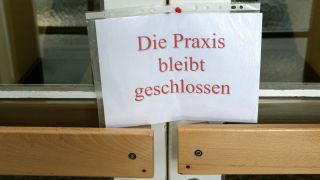 Ein Zettel an einer Tür mit der Aufschrift "Die Praxis bleibt geschlossen" (Symbolfoto: dpa/Pleul)
