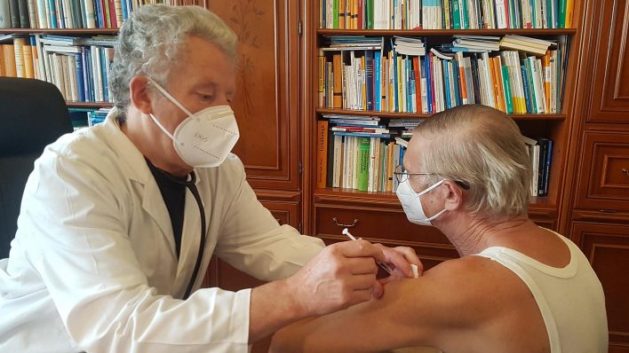 Der Spremberger Allgemeinmediziner Dr. Gerd Rust impft einen Patienten in seiner Praxis