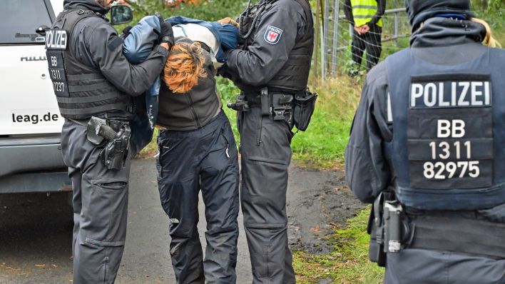 Ein Kohlegegner wird von der Polizei abgeführt, nachdem er eine Gleisverbindung für den Transport von Braunkohle zum Kraftwerk Jänschwalde blockiert hatte (Foto: dpa/Pleul)