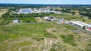 Auf dieser noch leeren Fläche am Rande eines Industriegebietes ist die Ansiedlung eines Werkes des kanadischen Rohstoff-Unternehmens Rock Tech Lithium geplant (Luftaufnahme mit einer Drohne) (Foto: dpa/Pleul)