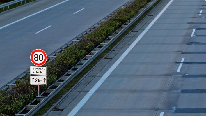 Ein Schild weist auf Straßenschäden und eine Temporeduzierung hin (Archivbild: dpa/Franke)