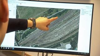 Student der BTU Cottbus-Senftenberg Lehrstuhl Eisenbahnwesen zeigt mit dem Finger auf einen Monitor, auf dem eine Luftaufnahme eines Bahnhofs zu sehen ist (Foto: rbb/Screenshot rbb24 Brandenburg Aktuell)