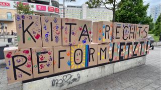 Auf gestalteten Pappkartons bei der Kundgebung steht "Kita-Rechtsreform jetzt!" (Foto: rbb/van Capelle)
