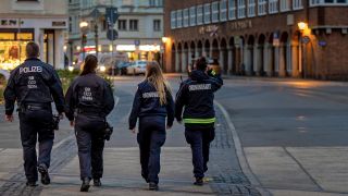 Mitarbeiter des Ordnungsamtes und Polizisten laufen über den Berliner Platz (Foto: dpa/Hammerschmidt)