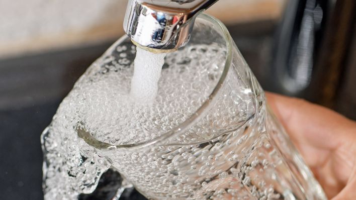 Am Wasserhahn in einer Küche wird ein Trinkglas mit Leitungswasser befüllt (Foto: dpa/Pleul)