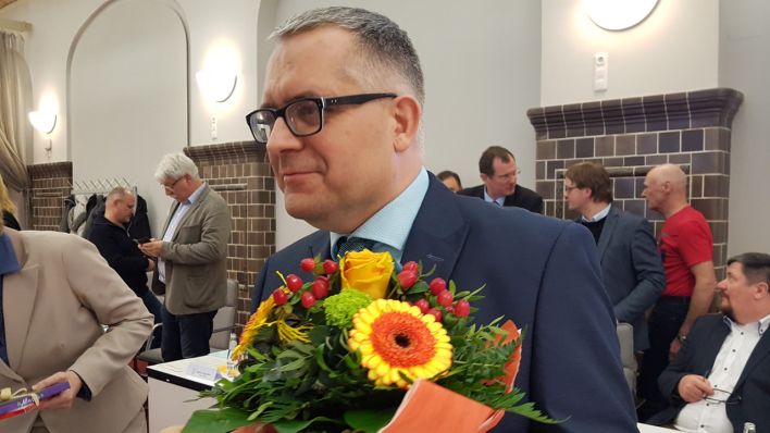 Georg Hanke nach seiner Wahl zum neuen Kreistagsvorsitzenden von Dahme-Spreewald mit einem Blumenstrauss.
