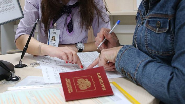Symbolbild: Eine russische Frau füllt in einem Visa-Zentrum in Berlin Anträge aus. (Quelle: imago images/Tass)