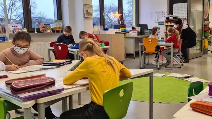 Kinder sitzen mit Mund-Nasen-Schutz an Aufgaben in der Fröbel Grundschule Cottbus (Foto: rbb/Schiller)