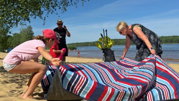 Touristen breiten am Senftenberger See eine Decke aus (Foto: rbb/Lepsch)